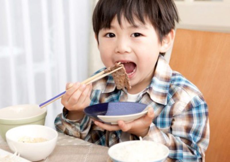 child eating with chopsticks