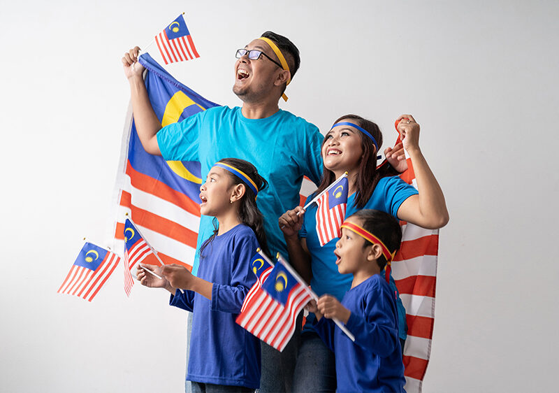 Malaysian family holding Malaysian flags