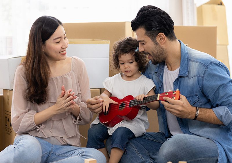 parents teaching child to play guitar
